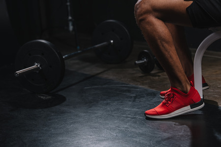 Cropped shot of African American sportsman in sneakers training in gymの写真素材