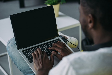 Cropped shot of African American man using laptop with blank screenの写真素材