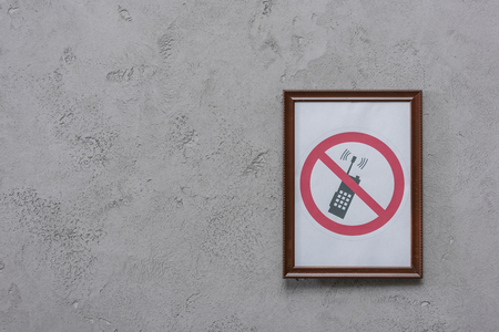 Frame with restricted phone placard on concrete wall backgroundの写真素材