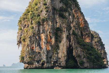 Beautiful scenic cliff with green vegetation in calm ocean at Krabi, Thailandの写真素材