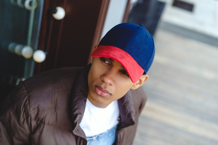 Thoughtful young man wearing cap in cityの写真素材