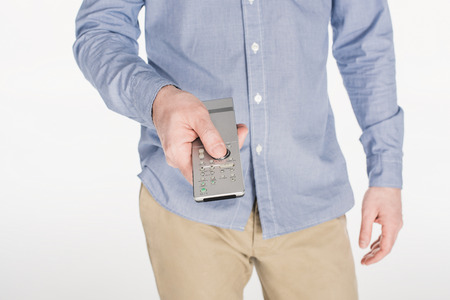 partial view of man holding remote control in hand isolated on white
