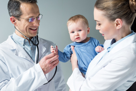 pediatricians checking breath of adorable little babyの写真素材