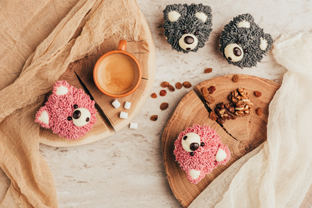 Top view of delicious muffins in shape of bears with cup of coffee on tableの写真素材