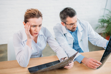 Doctor and shocked patient examining MRI scansの写真素材