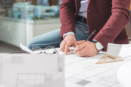 Cropped shot of architect drawing building plan