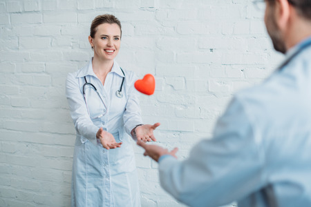 Doctors throwing toy heart to each otherの写真素材