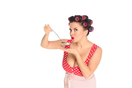 Emotional plus size housewife cooking with ladle looking at camera isolated on white backgroundの写真素材