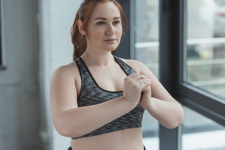 Overweight girl in sports top training in gym