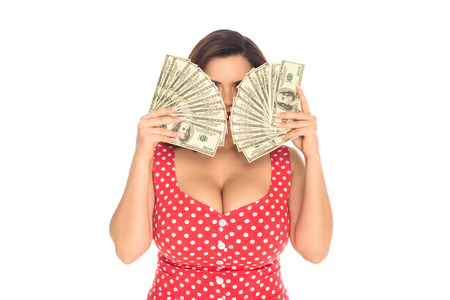Beautiful plus size woman covering face with lot of cash isolated on white background