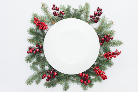 top view of pine tree wreath with Christmas decorations and round blank space in middle isolated on whiteの写真素材