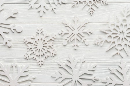 Flat lay with decorative snowflakes on white wooden tabletopの写真素材