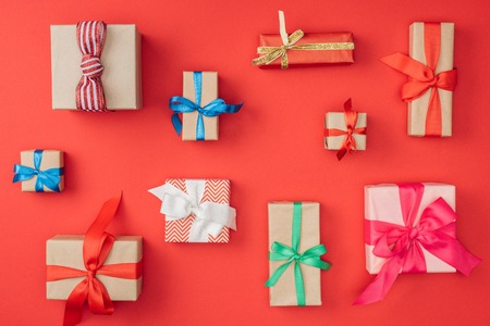 flat lay with arrangement of wrapped christmas presents isolated on red
