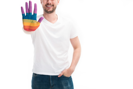 Cropped image of smiling homosexual man showing hand painted in colors of pride flag isolated on...