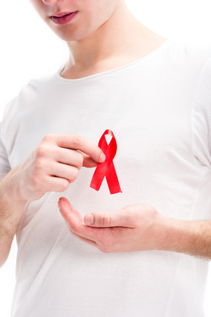 cropped image of man showing red ribbon on shirt isolated on white, world aids day concept