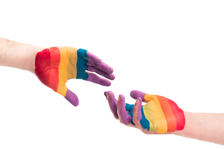 cropped image of gay couple reaching hands painted in colors of pride flag isolated on white, world aids day conceptの写真素材