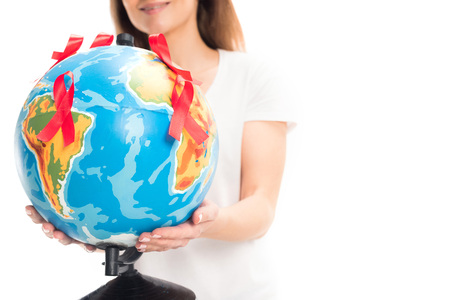 cropped image of woman holding globe with red ribbons isolated on white, world aids day conceptの写真素材