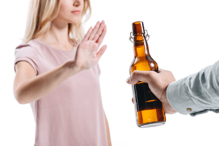 cropped image of blonde woman rejecting bottle of unhealthy beer isolated on whiteの写真素材