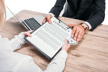 cropped image of businessman rejecting bribe in clipboard with contract in office isolated on whiteの写真素材