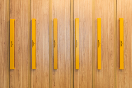 full frame view of wooden lockers with yellow handles in kindergartenの写真素材