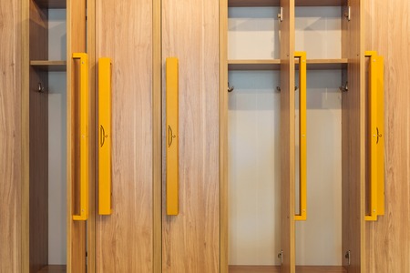 full frame view of wooden lockers with yellow handles in kindergarten cloakroomの写真素材