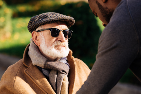 Close-up shot of senior man looking at African american man on streetの写真素材