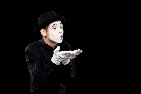mime sending air kiss isolated on blackの写真素材