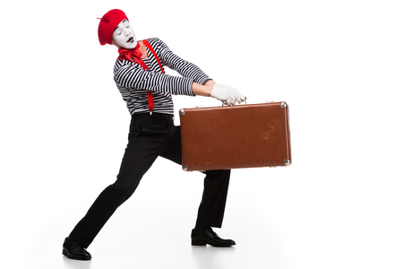 mime carrying heavy brown suitcase isolated on whiteの写真素材