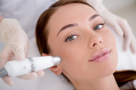 partial view of woman getting facial treatment in cosmetology salonの写真素材