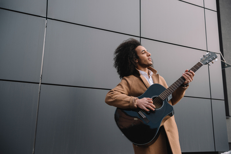 african american street musician playing guitar outdoorsの写真素材
