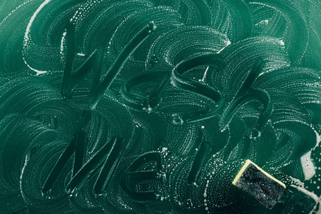 top view of words wash me written with foam on dirty green tabletop