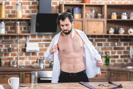 muscular handsome loner businessman wearing shirt at kitchenの写真素材