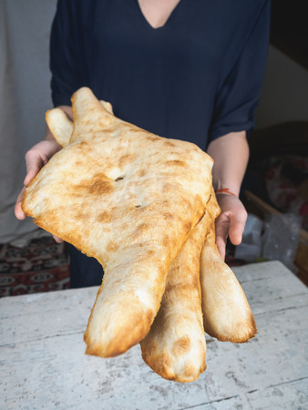 close-up view of person holding delicious traditional georgian flatbreadsの写真素材