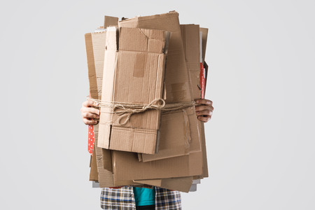 cropped shot of man holding pile of folded cardboard boxes isolated on grey, recycling conceptの写真素材