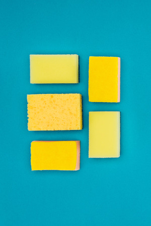 top view of yellow washing sponges isolated on blueの写真素材