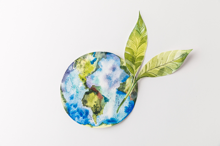 top view of handmade colorful paper globe with green leaves isolated on grey, environment protection and recycling conceptの写真素材