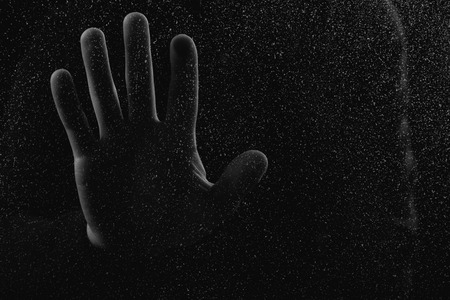 close-up partial view of human hand touching glass with glitches