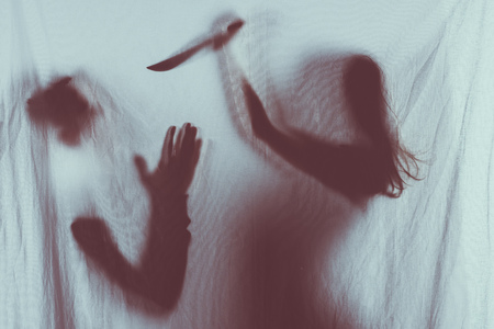 silhouette of someone holding knife and murdering victim, crime conceptの写真素材