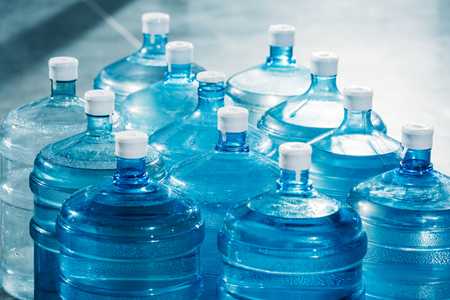 Plastic large blue water bottles on floorの写真素材