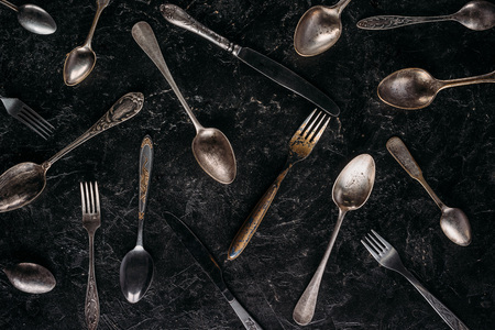 Vintage spoons and forks with knives on dark backgroundの写真素材