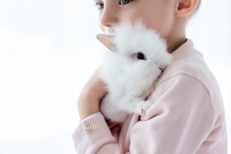 Adorable kid hugging white rabbitの写真素材