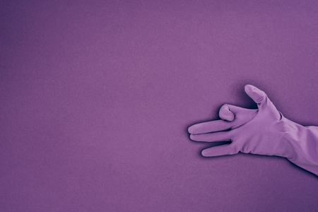 cropped image of woman showing sign with hand in rubber protective glove isolated on violetの写真素材