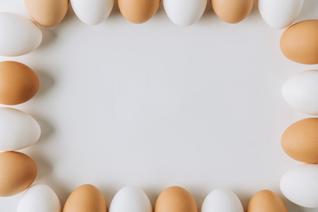 white and brown eggs laying on on white background and forming square