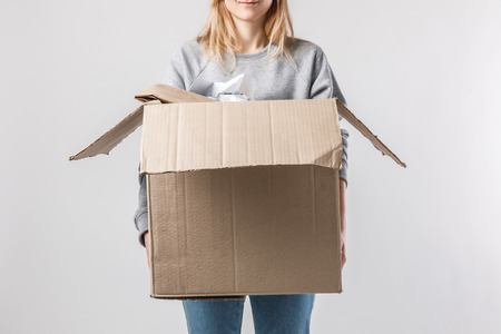 partial view of woman holding cardboard box with garbage in hands, recycle conceptの写真素材