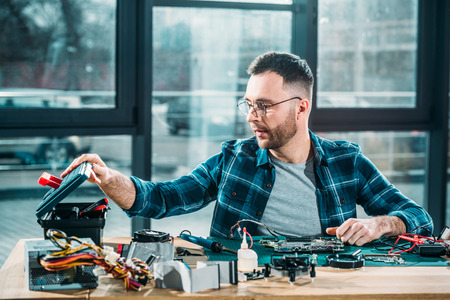 Hardware engineer with instruments and circuit board at workplaceの写真素材