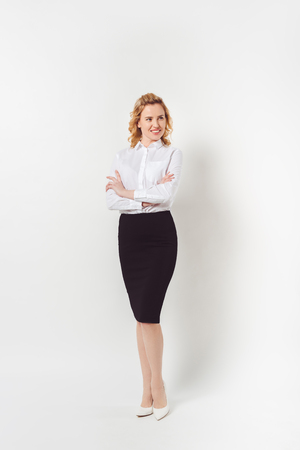 stylish businesswoman in white shirt with crossed arms on whiteの写真素材