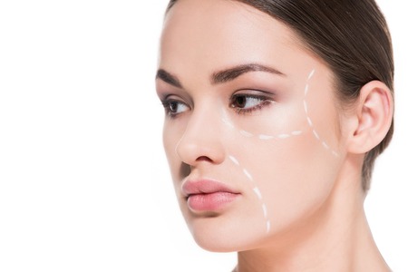 beautiful young woman with dotted line drawn on face for plastic surgery isolated on white