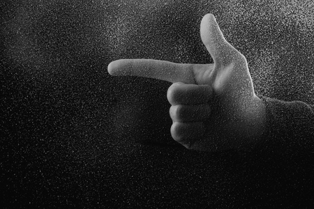 cropped shot of person pointing away with finger in darknessの写真素材