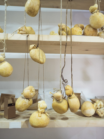 close-up view of delicious smoked cheese hanging on ropesの写真素材