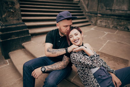 beautiful happy young couple in love sitting on stairs in Dresdenの写真素材